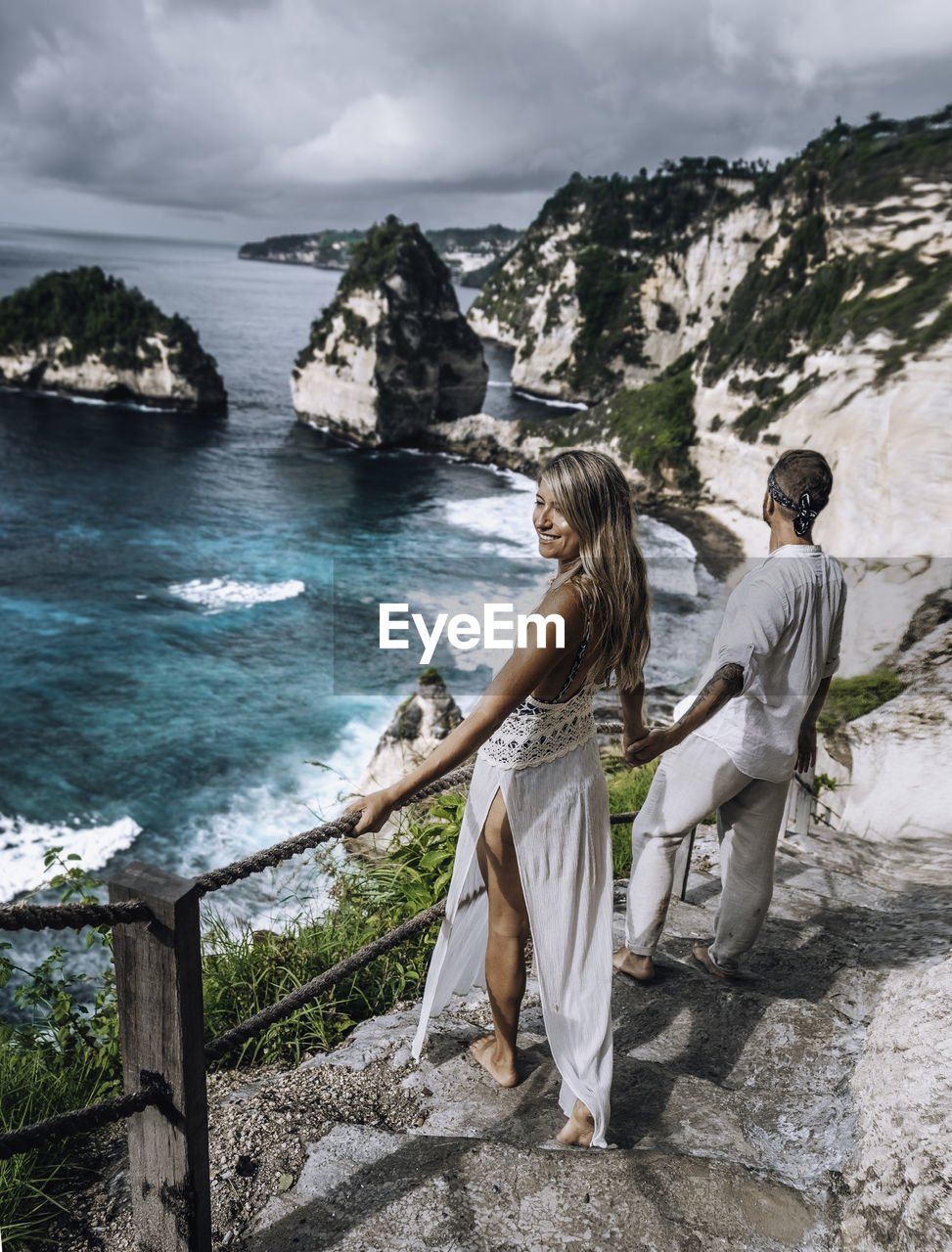 A couple at the famous diamond beach of nusa penida / bali.