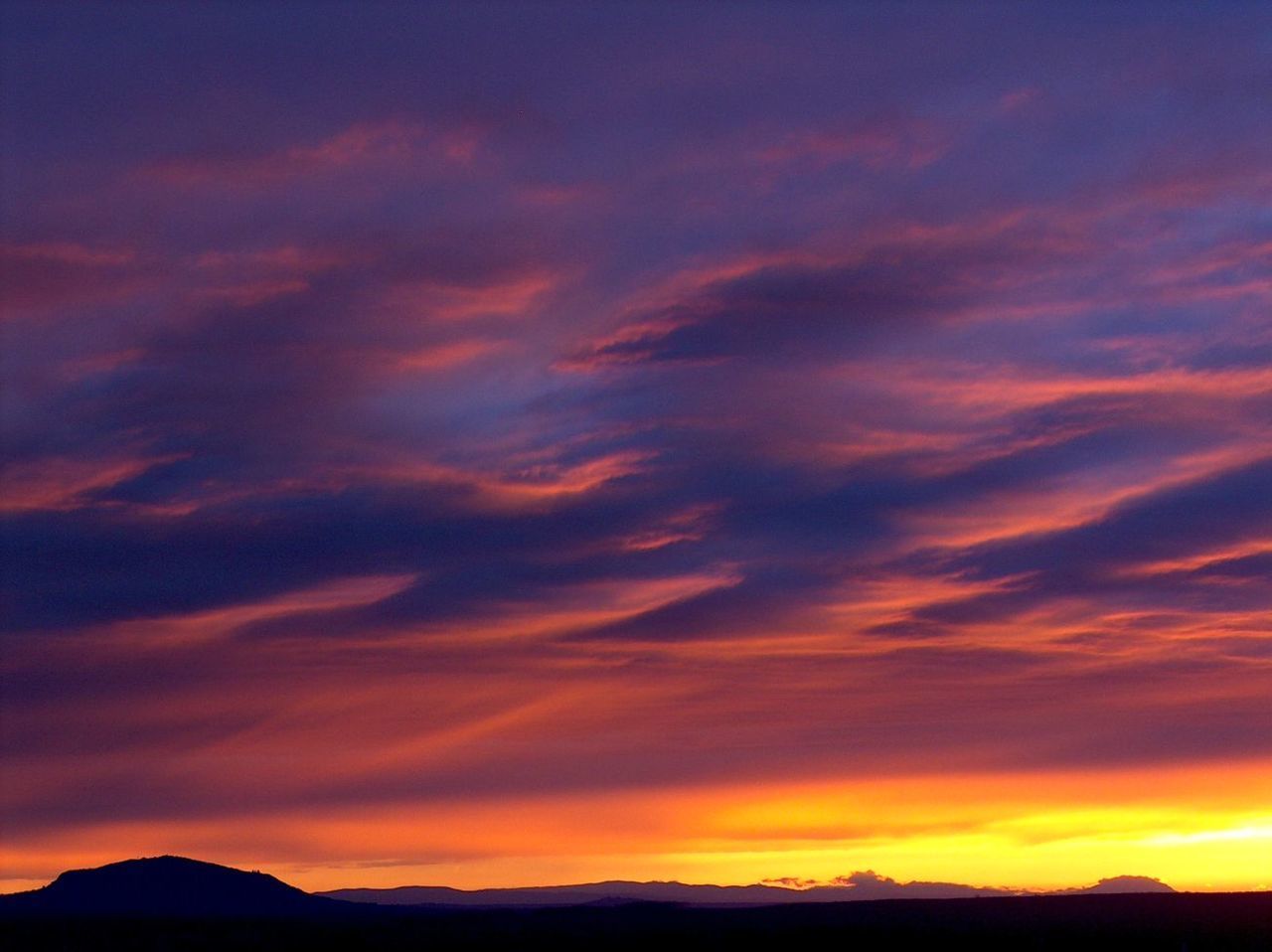 SILHOUETTE MOUNTAINS AGAINST DRAMATIC SKY