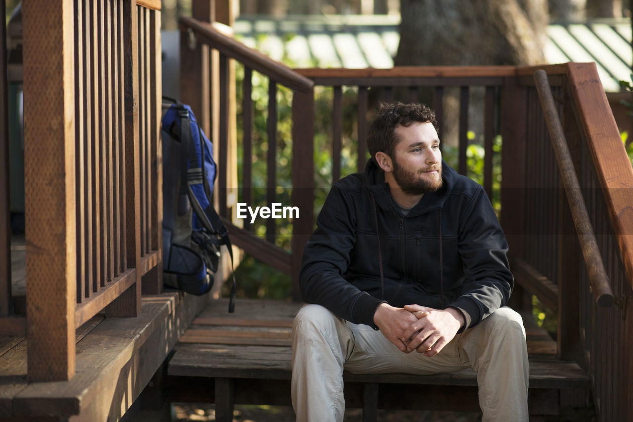 Man looking away while sitting on steps