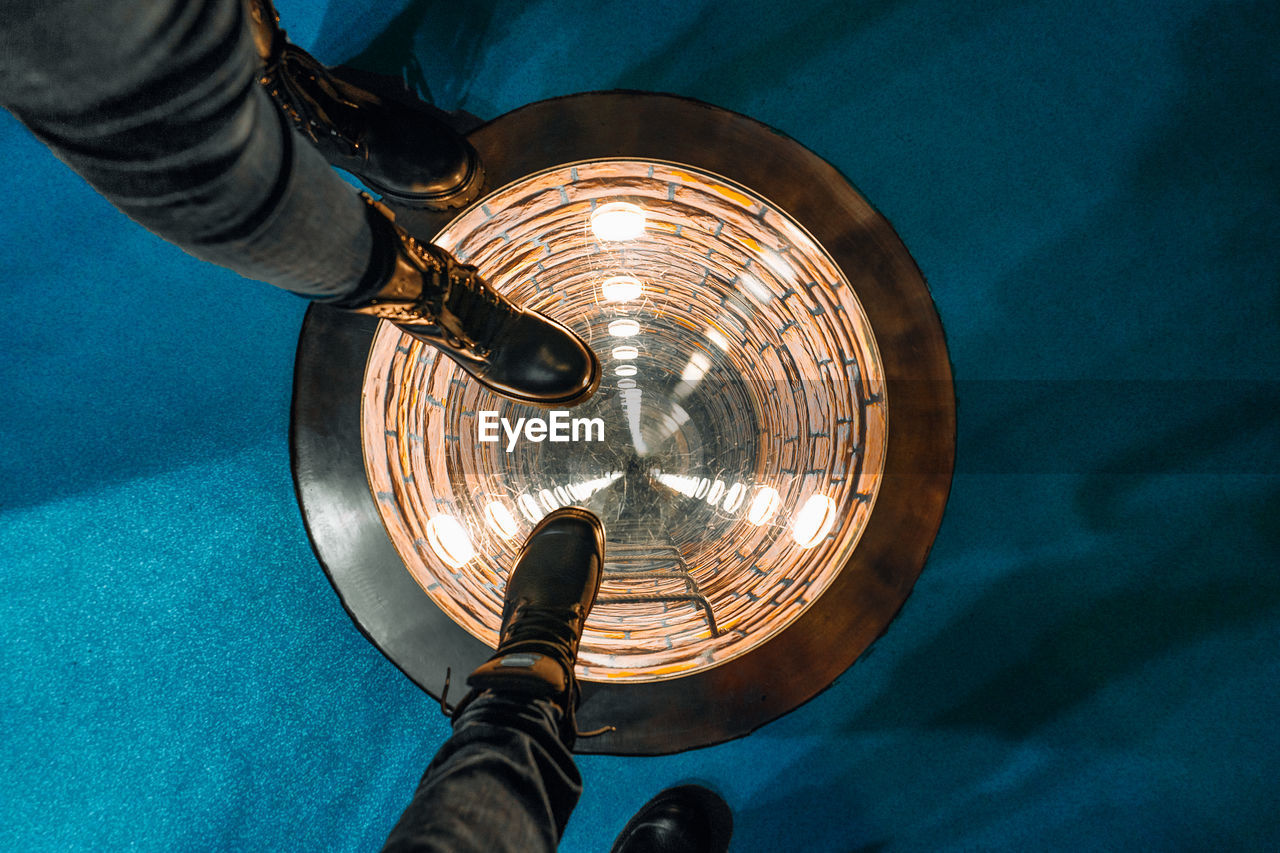 Shoes stepping on round illuminated well