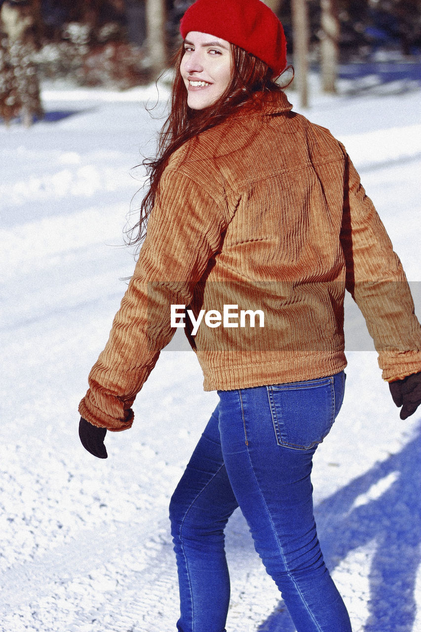 Portrait of smiling woman walking on snow