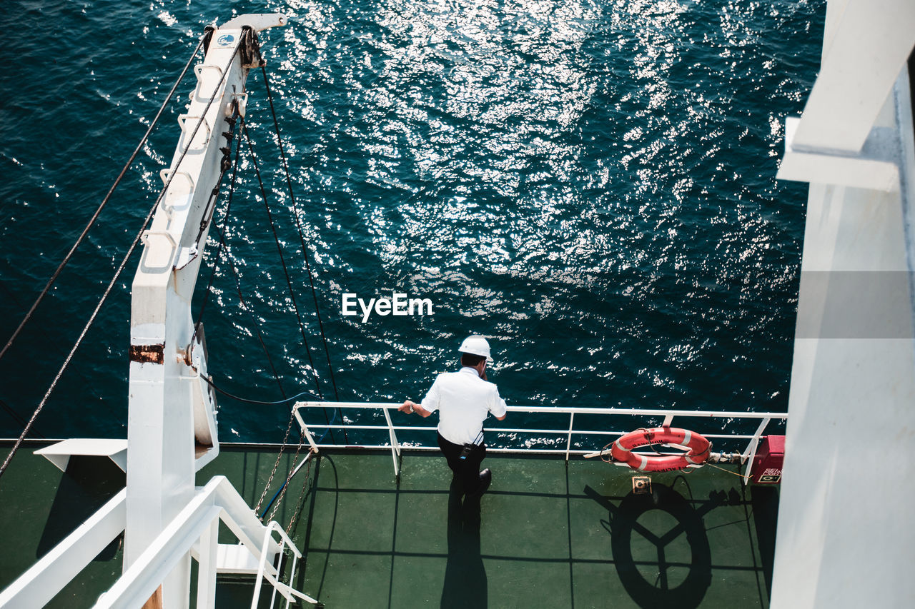 High angle view of man standing on boat in sea