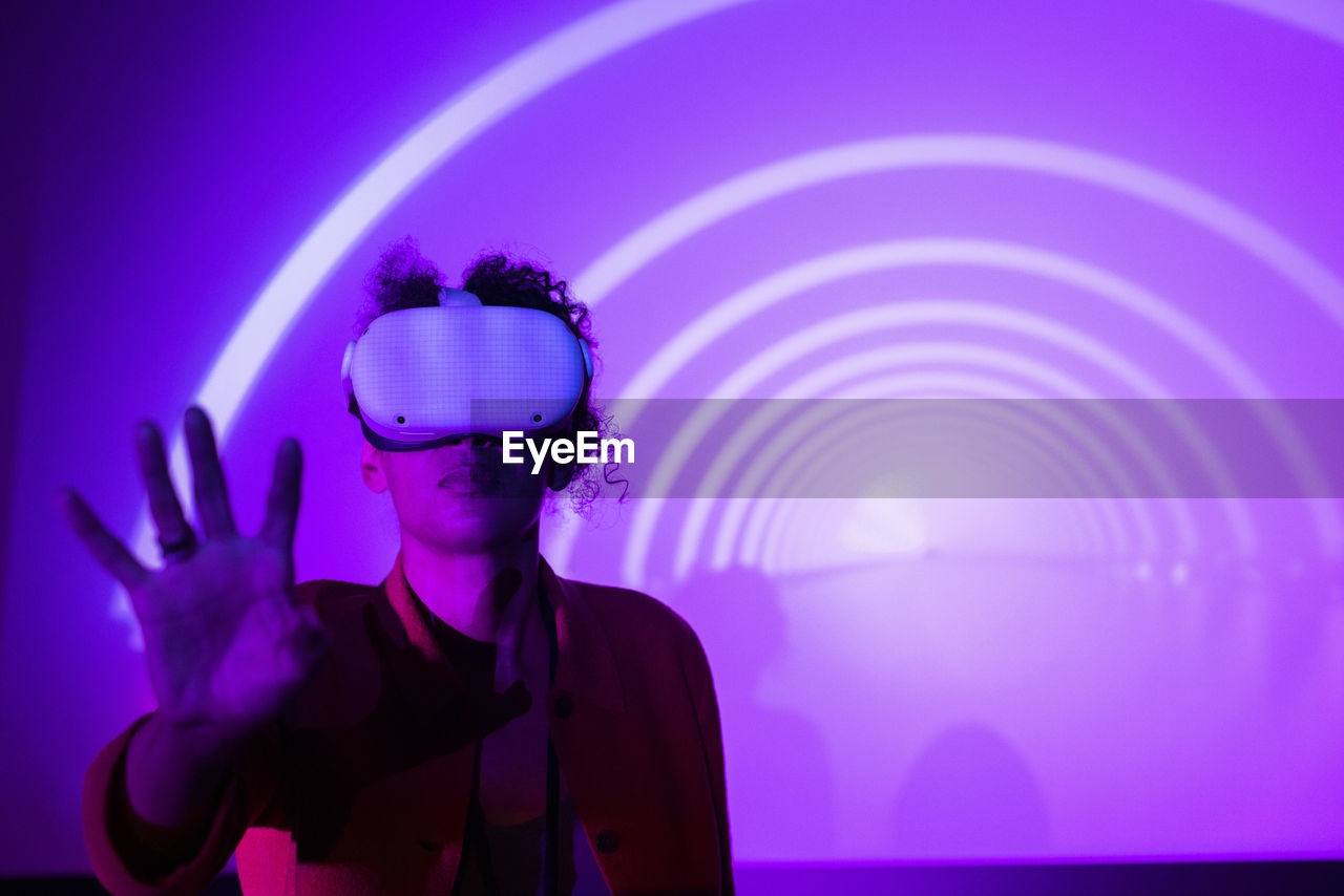 Female entrepreneur wearing futuristic glasses against projection screen in exhibition center