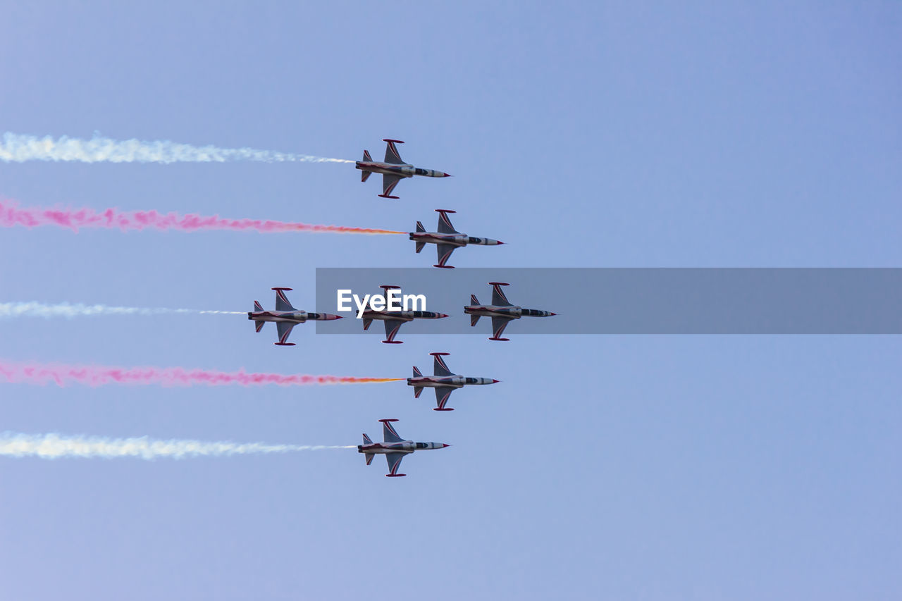 Low angle view of airshow against clear sky