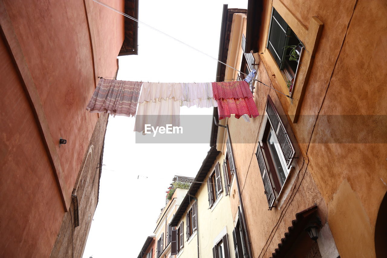 Low angle view of clothes drying against sky