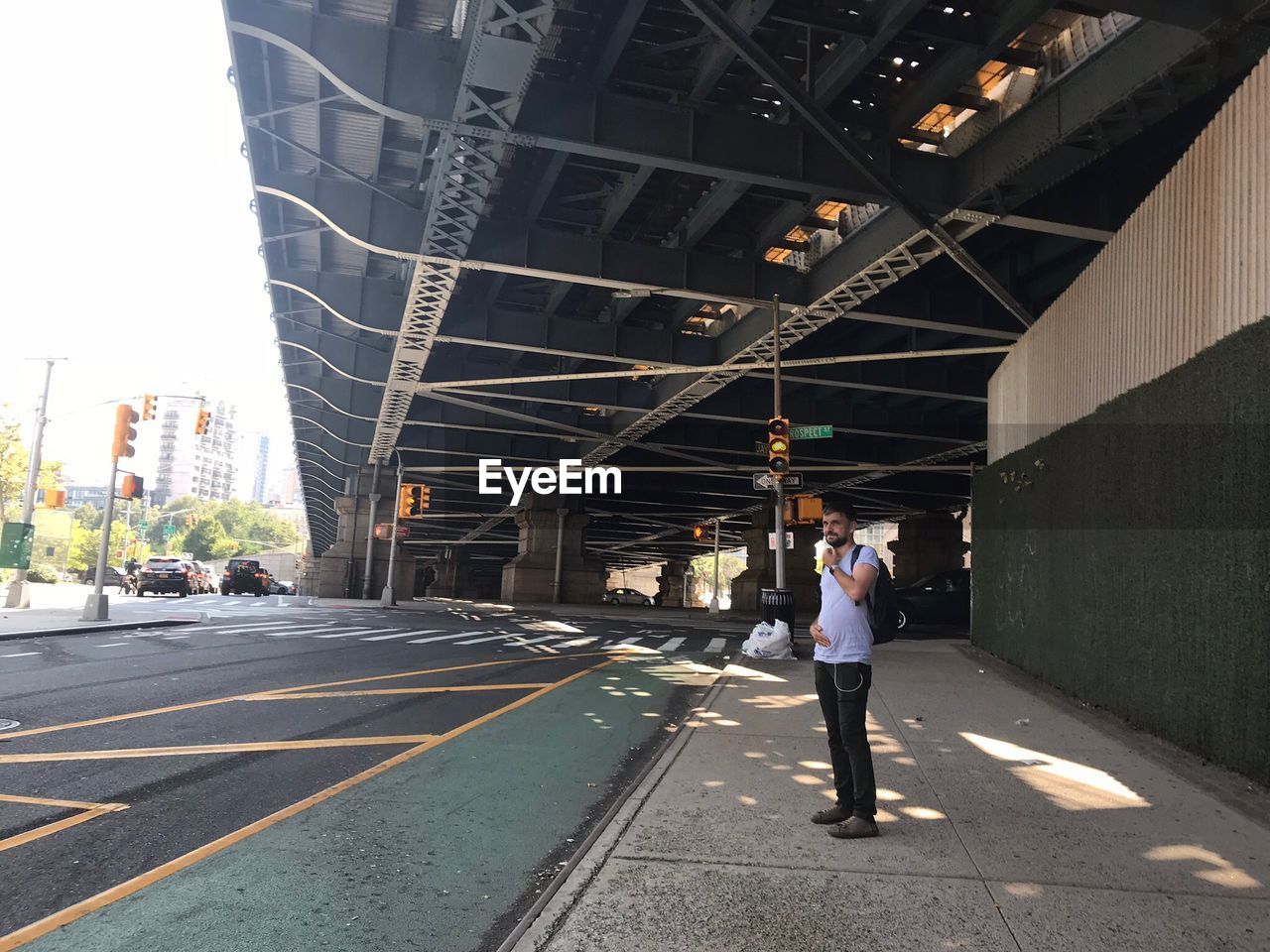 Man standing on sidewalk in city