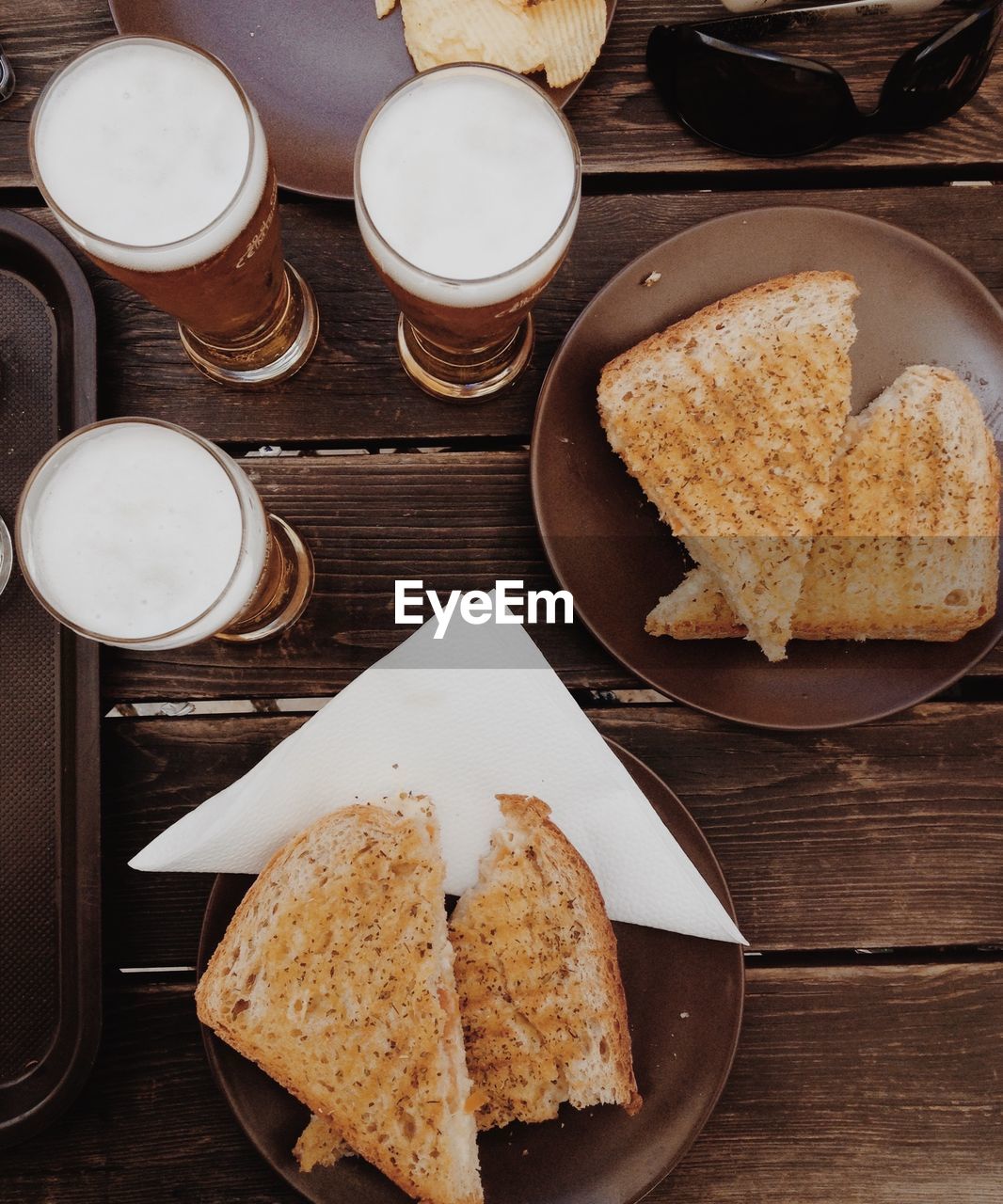 High angle view of beer glasses with sandwiches on table