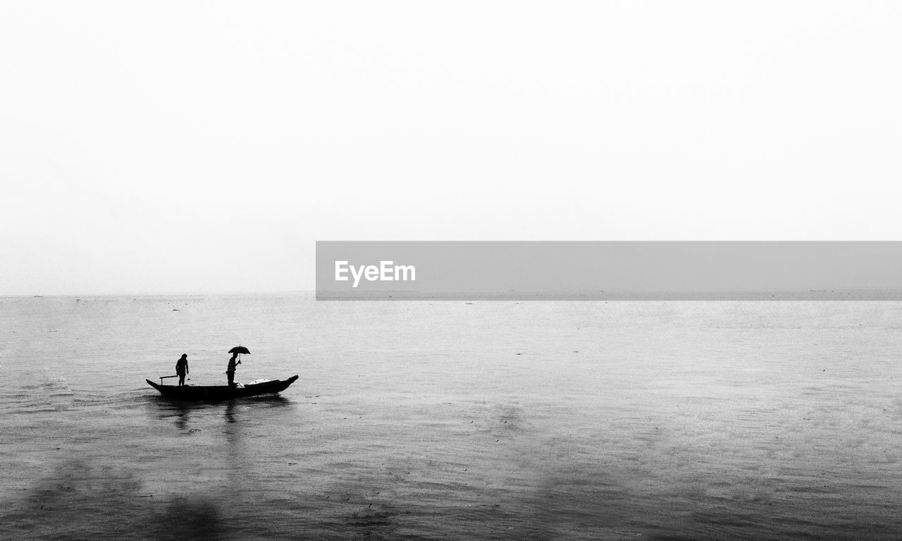 High angle view of fisherman in boat against sky