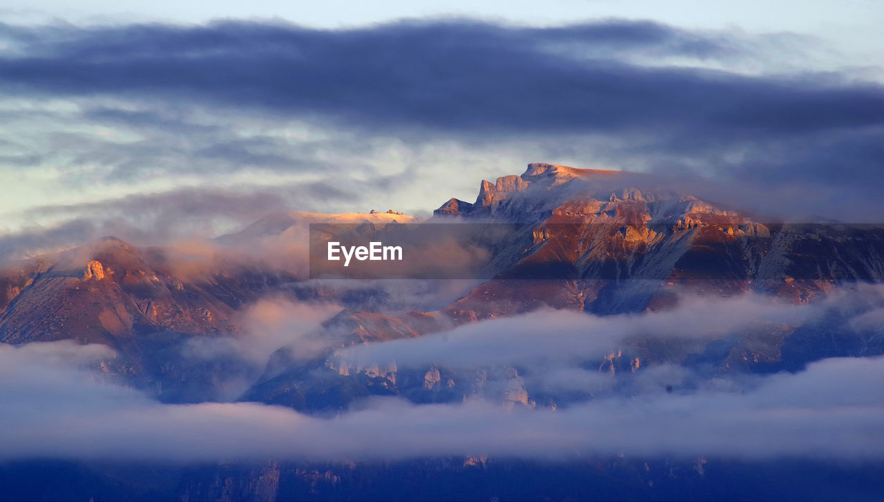 Aerial view of majestic mountains against sky during sunset