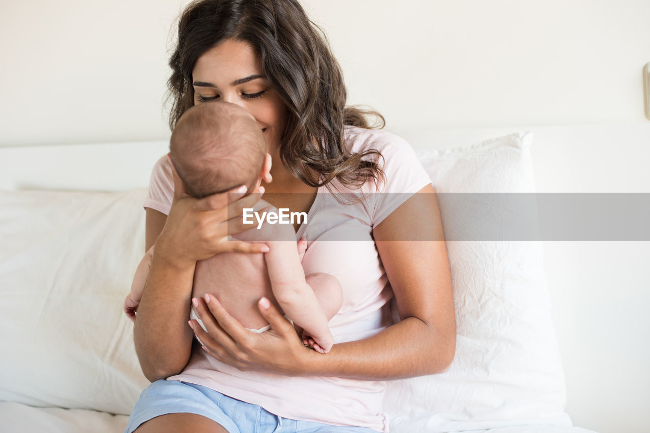 MIDSECTION OF WOMAN SITTING WITH HANDS