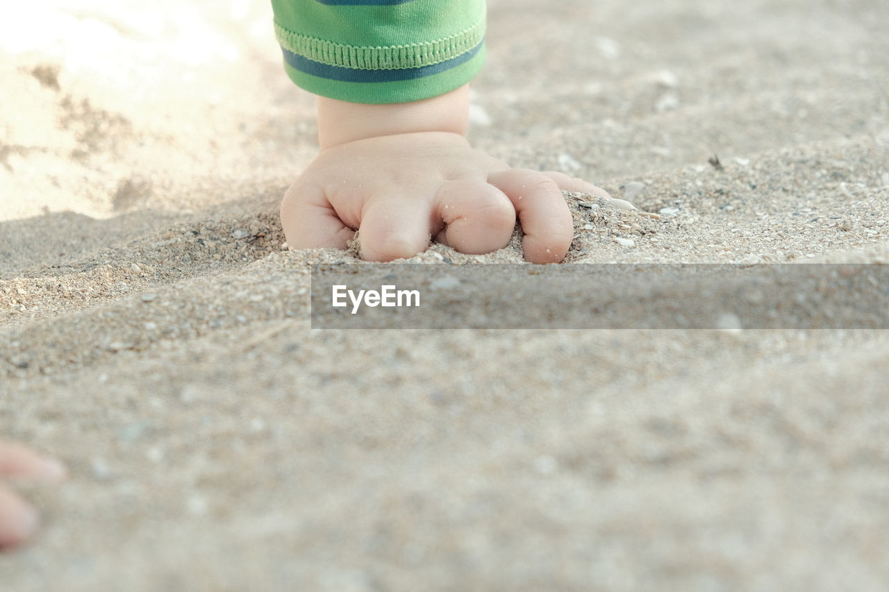 Baby hand in sand