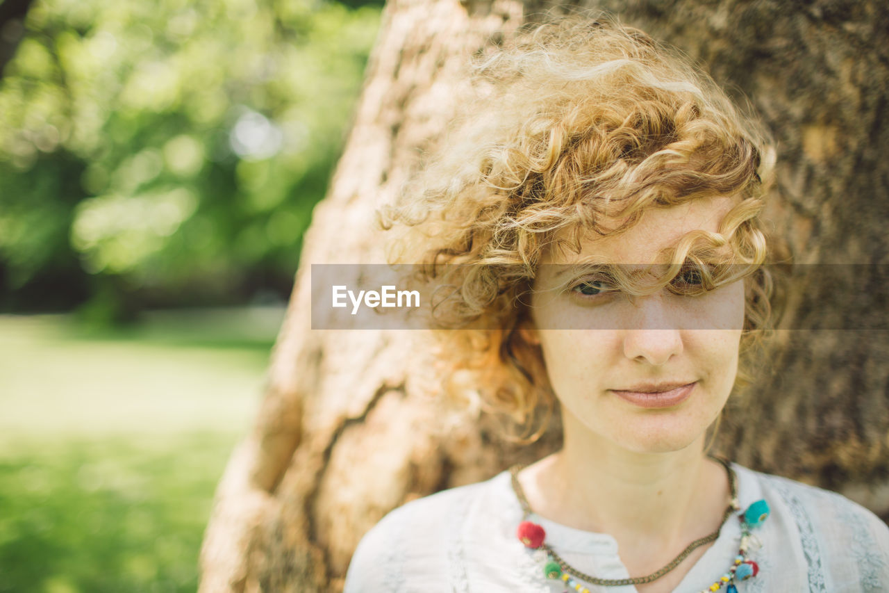 Portrait of smiling young woman with curly blond hair