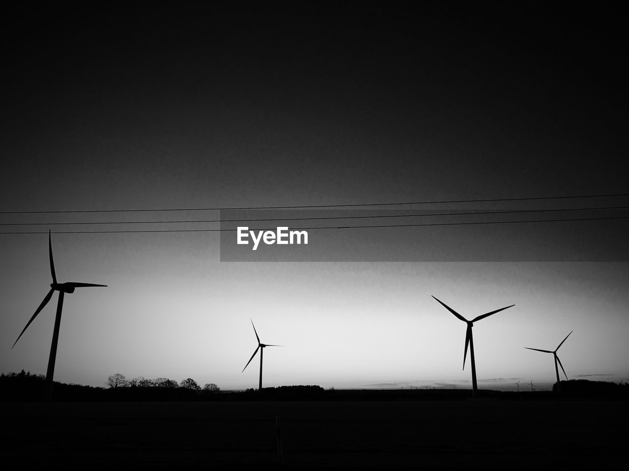 LOW ANGLE VIEW OF WIND TURBINES IN FIELD