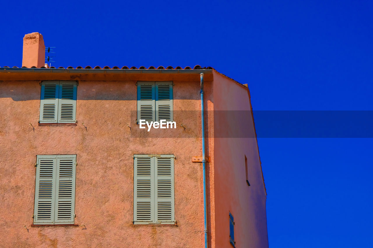 Low angle view of building against clear blue sky