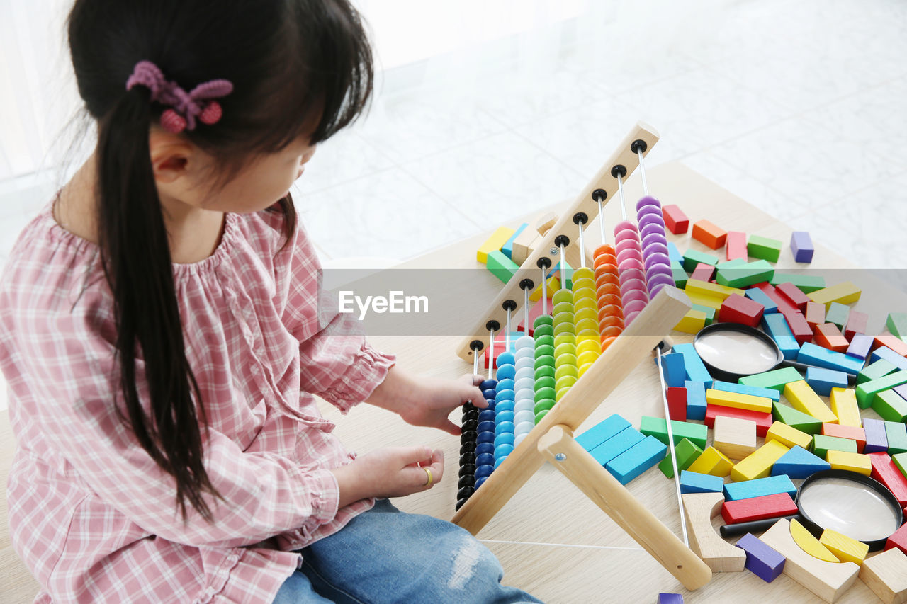 Girl playing with abacus on table