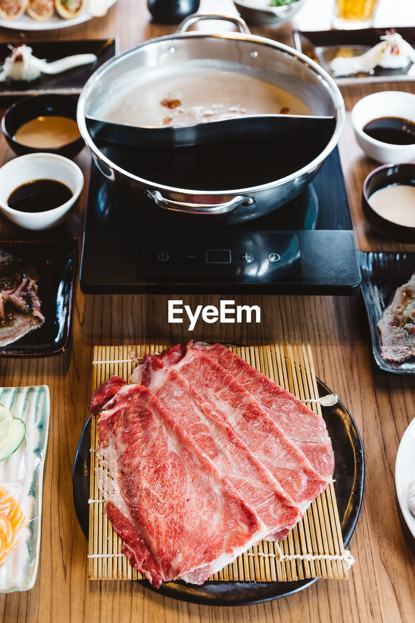 HIGH ANGLE VIEW OF MEAT IN PLATE ON TABLE