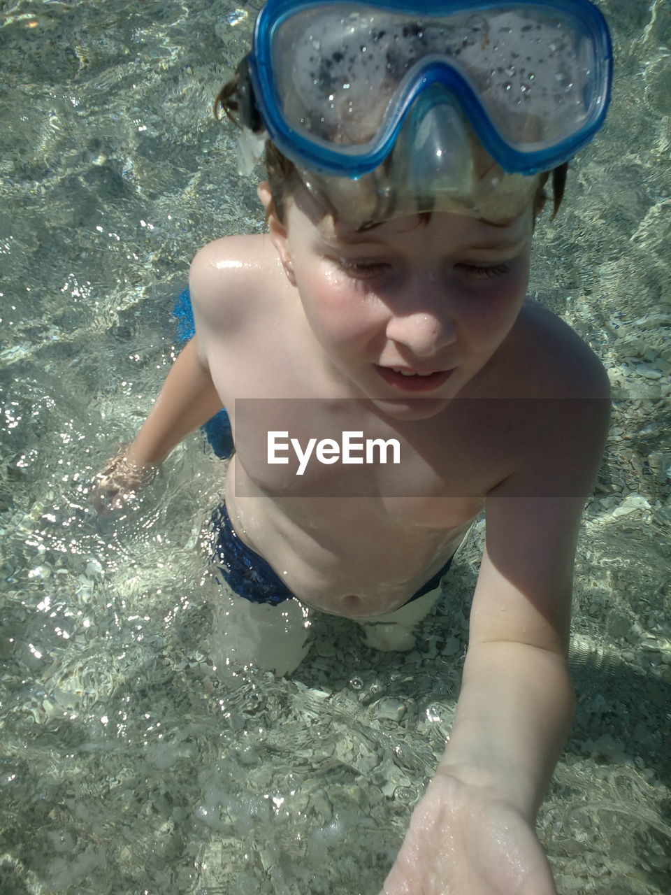 High angle view of shirtless boy with snorkel standing in sea during summer