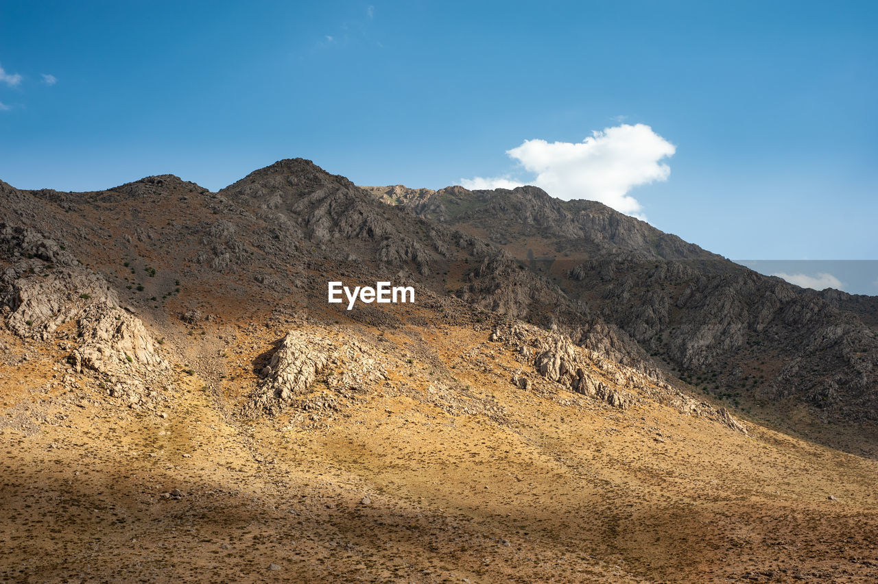 The shadow of clouds on a rocky mountain with autumnal foliage, rocky mountain khuzestan province, 