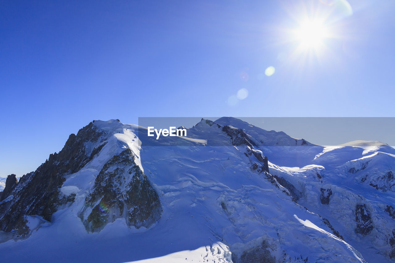 Scenic view of snowcapped mountains against clear blue sky