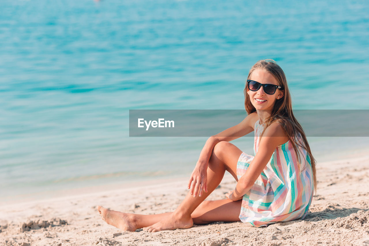 Portrait of young woman wearing sunglasses on beach