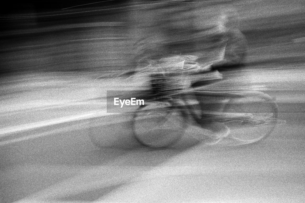 Blurred motion of person cycling on road