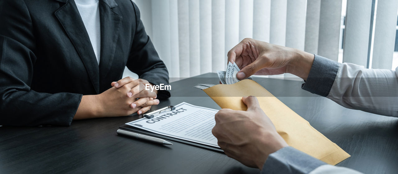 REAR VIEW OF A MAN AND WOMAN ON TABLE AT OFFICE