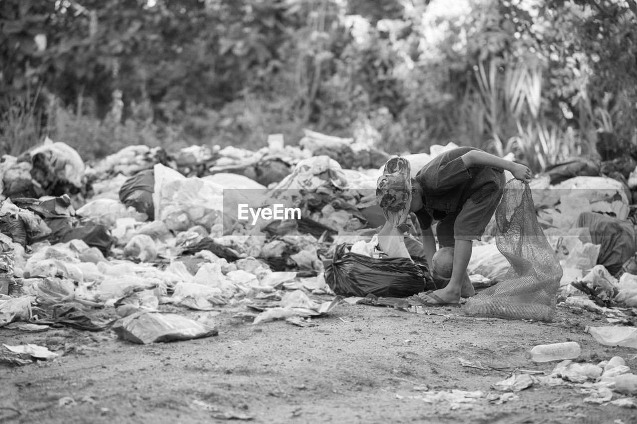 SIDE VIEW OF MAN ON FIELD AGAINST ROCKS