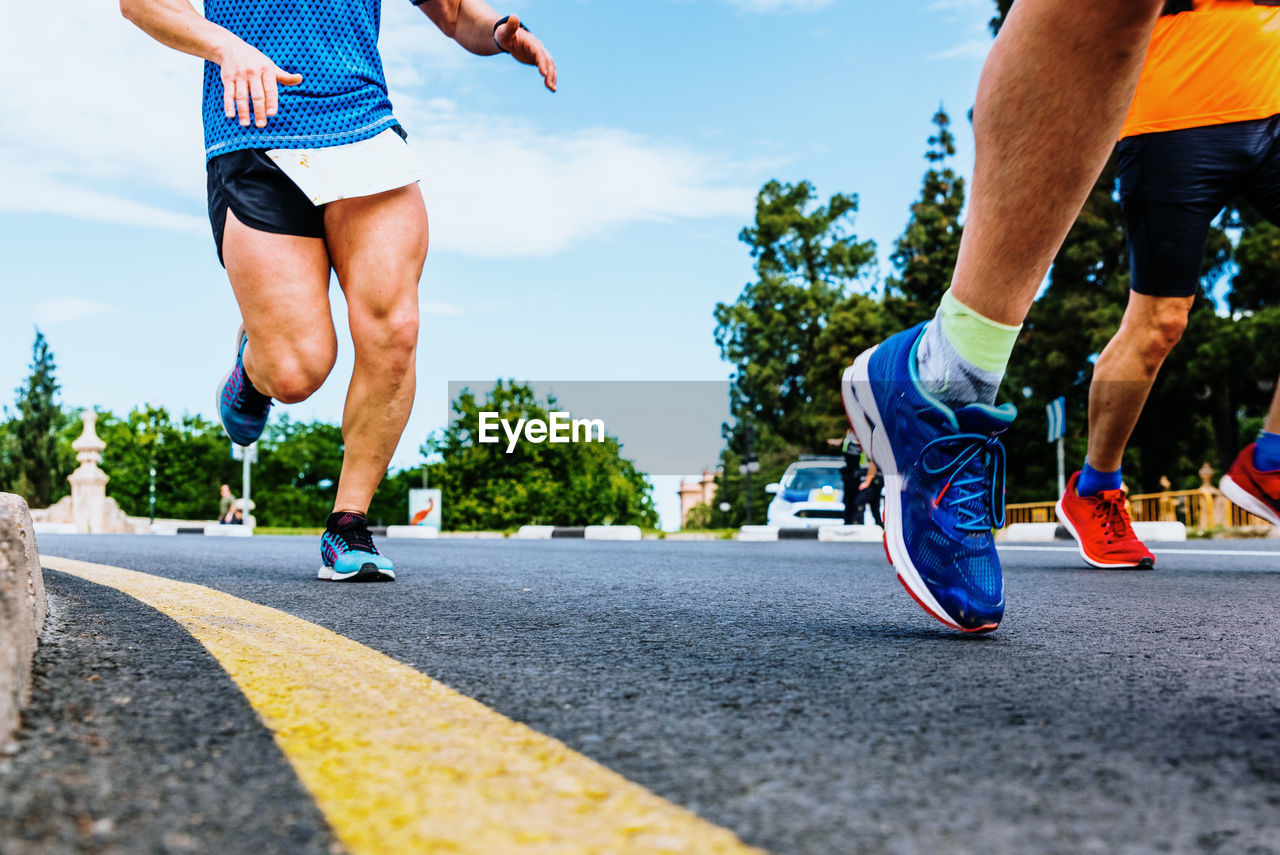 Low section of men running on road