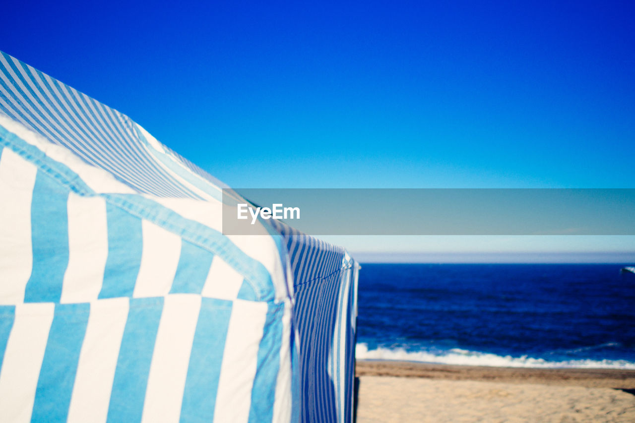 Blue tent at beach against sky