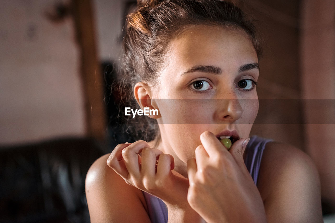 Close-up portrait of teenage girl eating grape