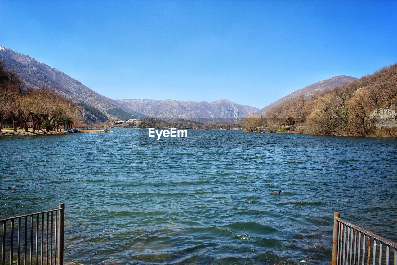 Scenic view of lake against clear blue sky