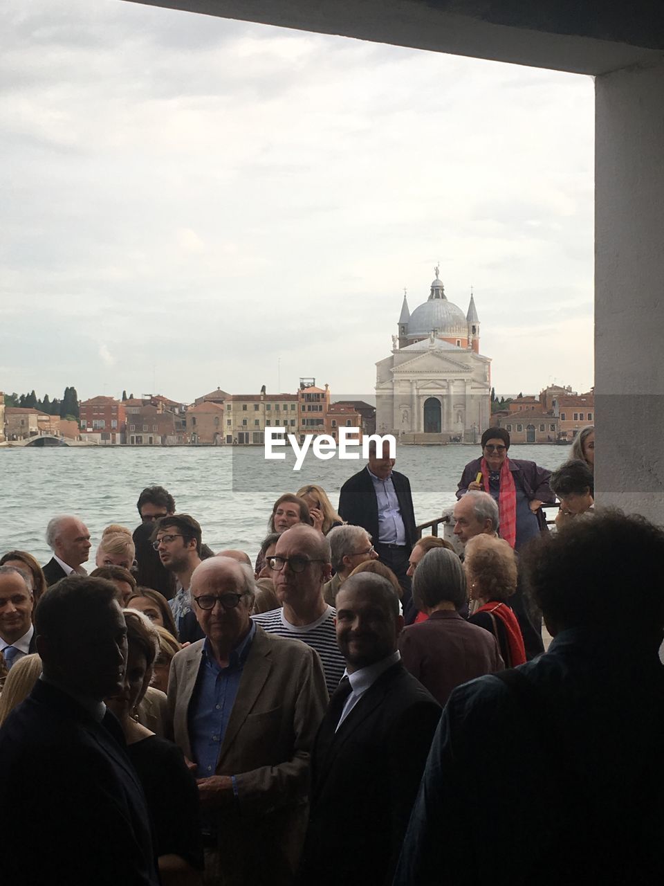 GROUP OF PEOPLE IN FRONT OF BUILDINGS AGAINST SKY