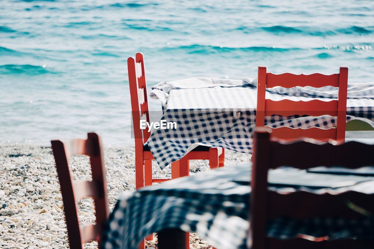 water, sea, beach, nature, land, red, ocean, no people, chair, day, relaxation, sunlight, outdoors, beauty in nature, wood, travel destinations, tranquility, vacation, summer, seat, holiday, trip, tranquil scene, travel, scenics - nature