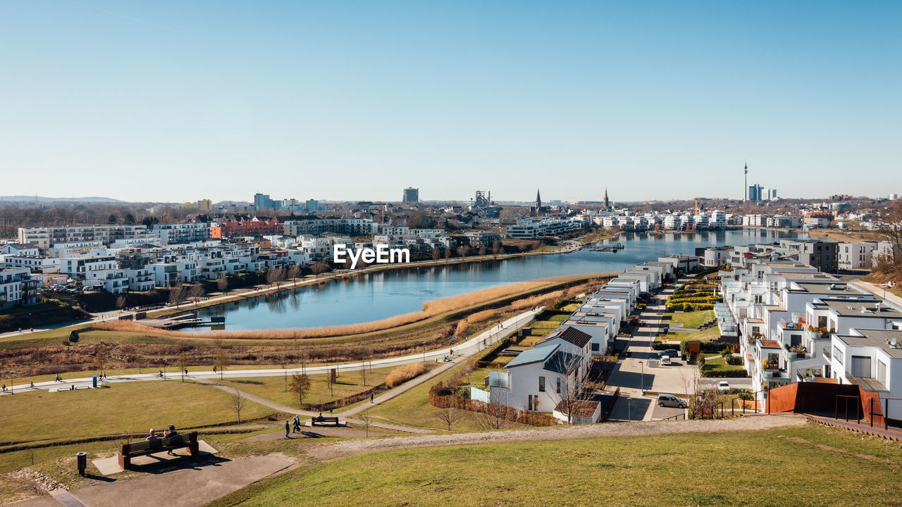 High angle view of river amidst buildings against clear sky