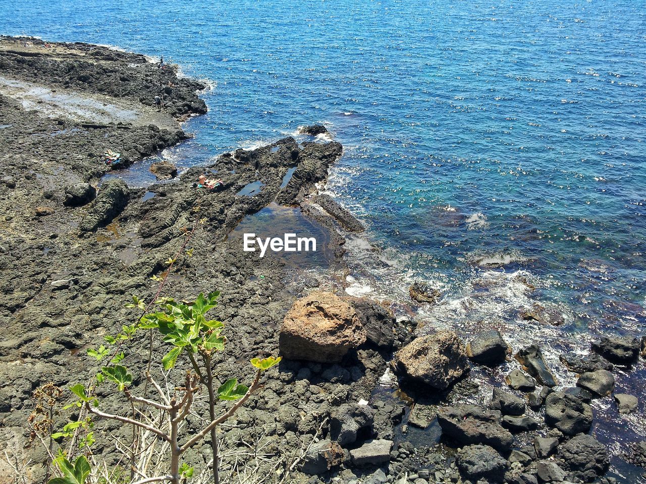 HIGH ANGLE VIEW OF ROCKS ON SHORE AT SEA