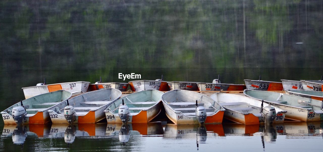 BOATS MOORED BY LAKE