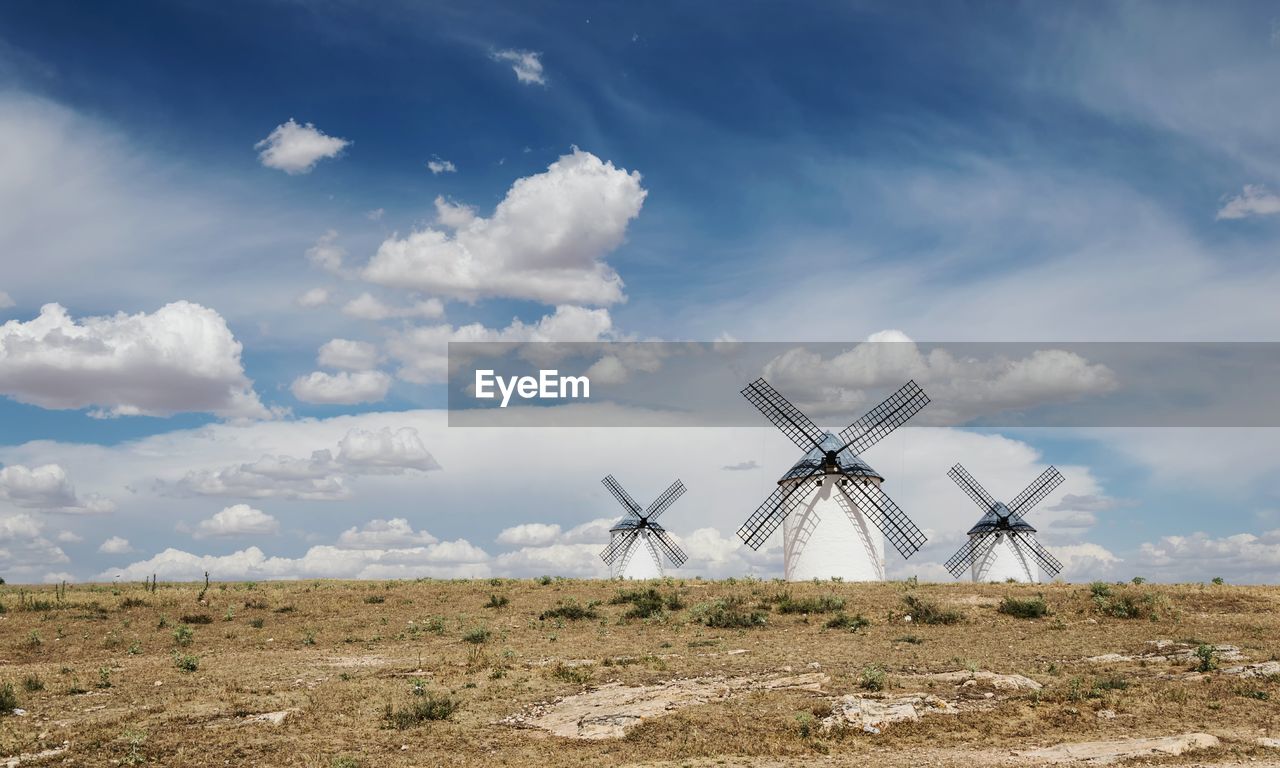 Traditional windmill on field against sky