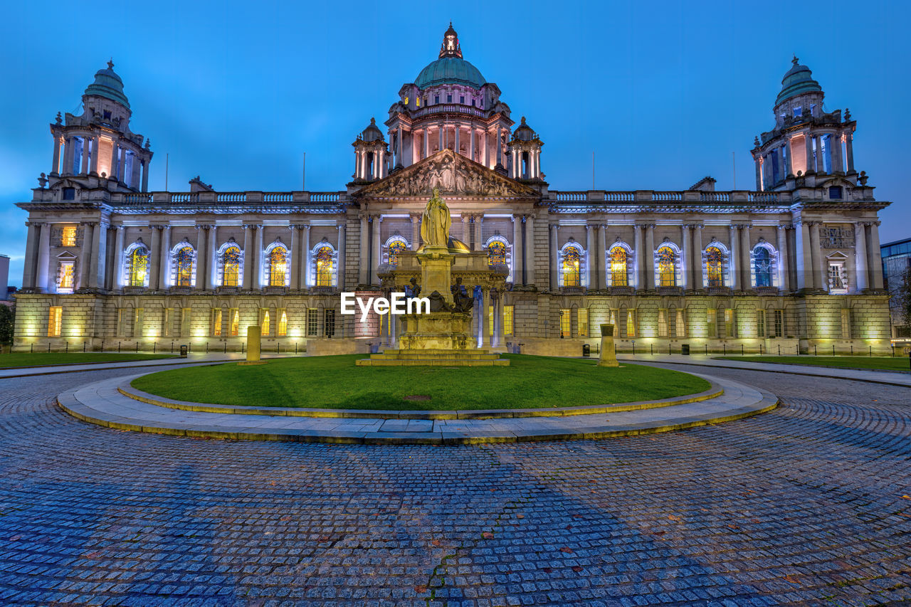 The illuminated belfast city hall at dawn