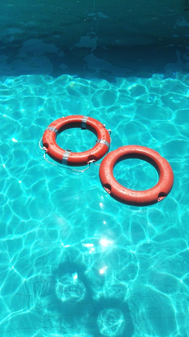 High angle view of life belts floating on swimming pool