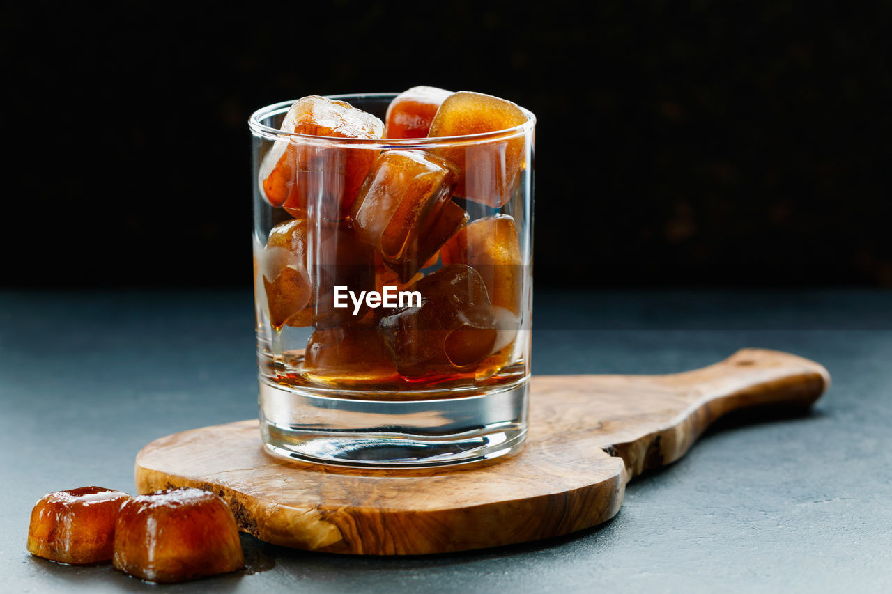 Close-up of ice cubes in glass on table against black background