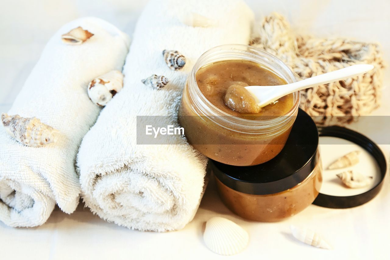 High angle view of rolled towels and beauty products on table