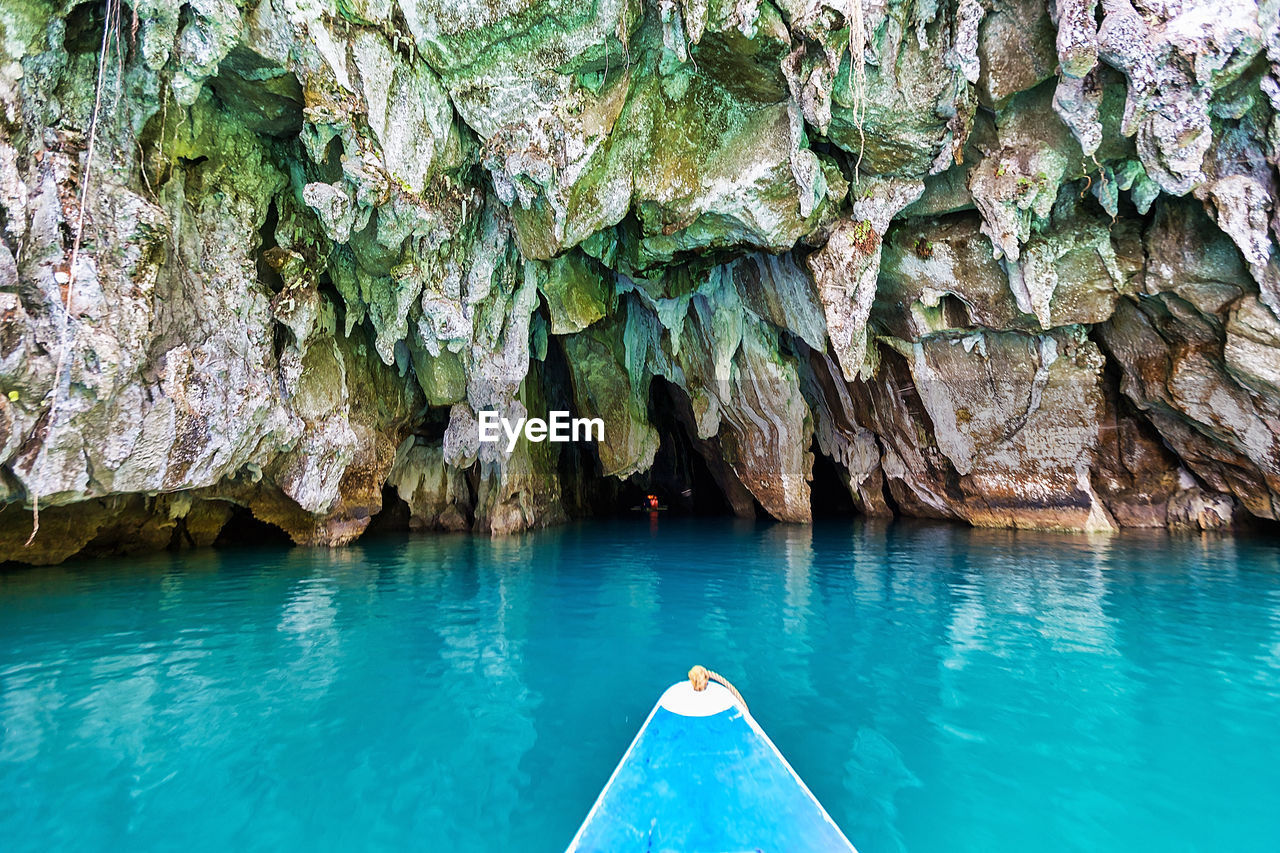 Boat on sea against rock formations