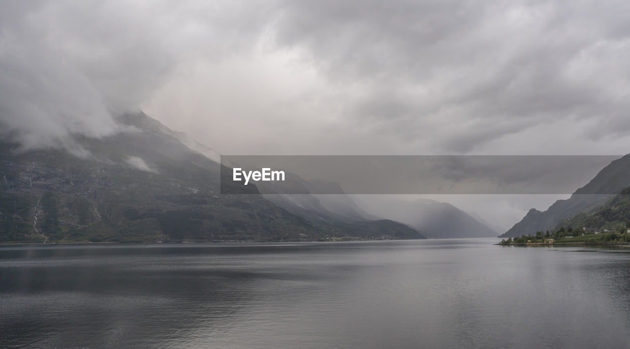 SCENIC VIEW OF LAKE BY MOUNTAIN AGAINST SKY