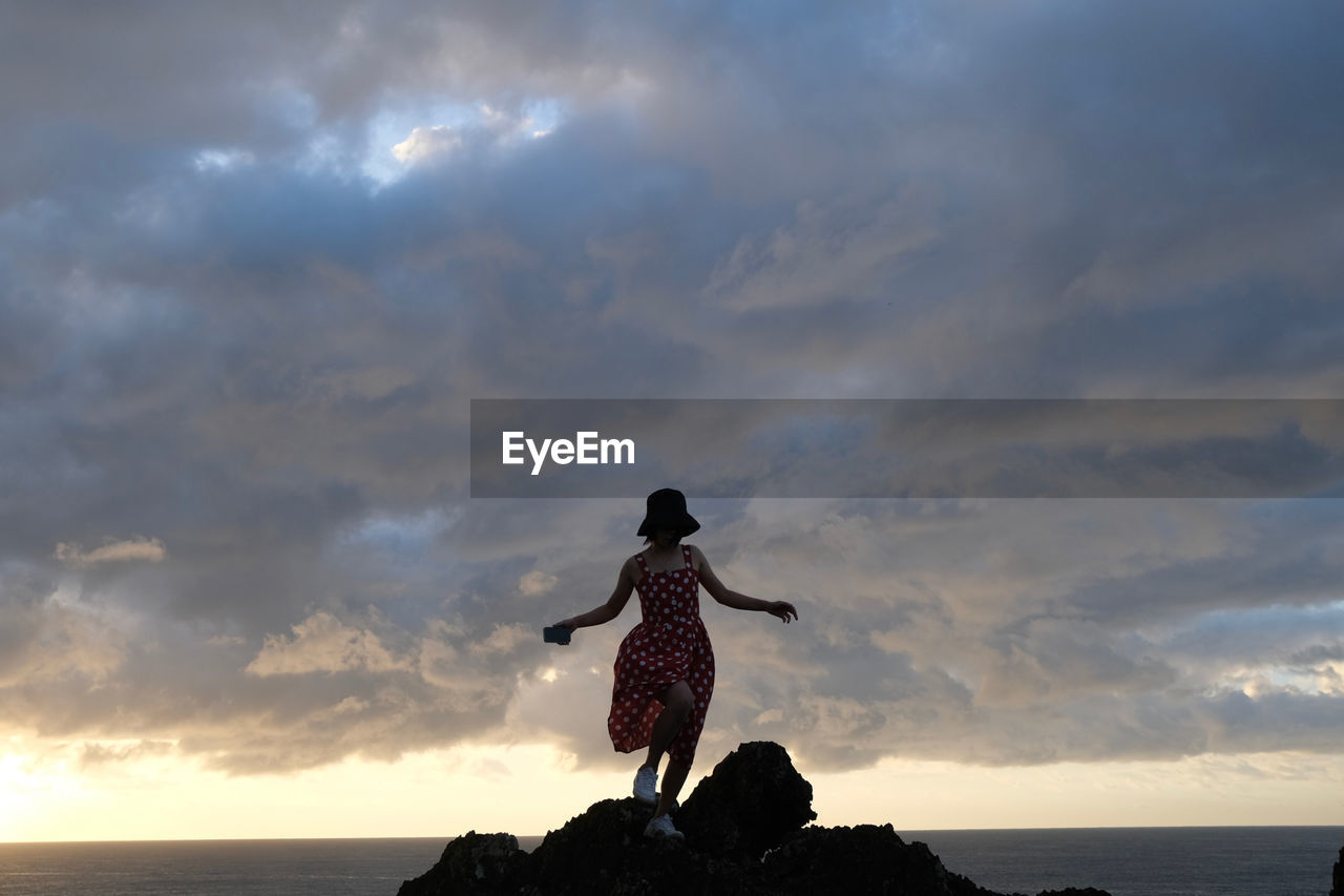 low angle view of statue against cloudy sky during sunset