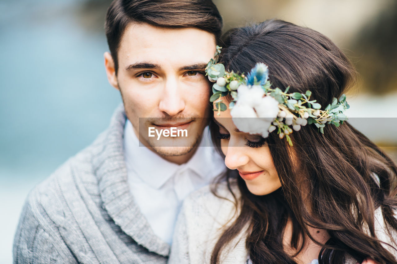 PORTRAIT OF A SMILING YOUNG COUPLE ON FLOWER