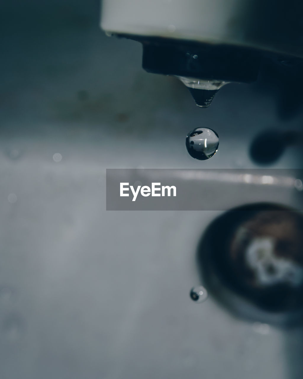 CLOSE-UP OF WATER DROPS ON ILLUMINATED FAUCET