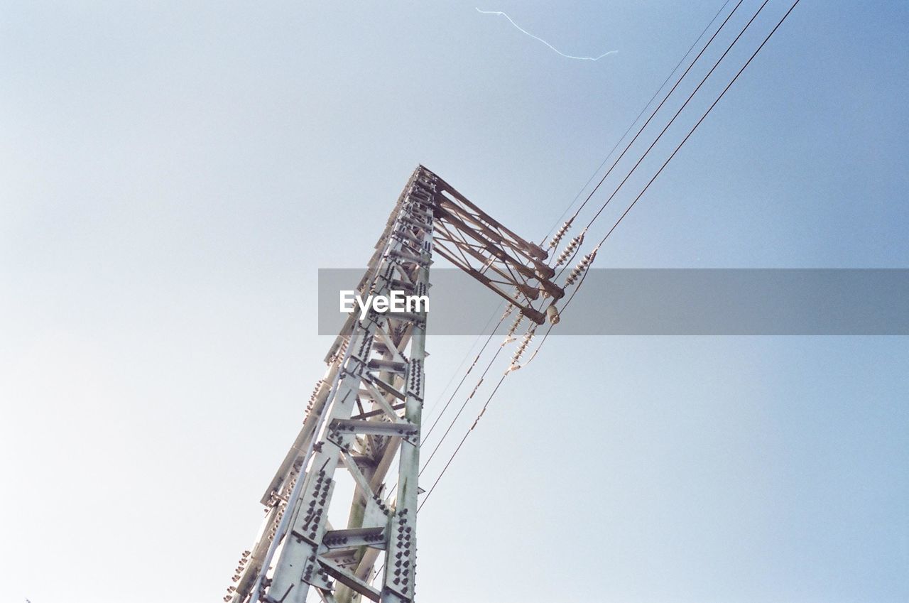 Low angle view of electricity pylon against clear sky