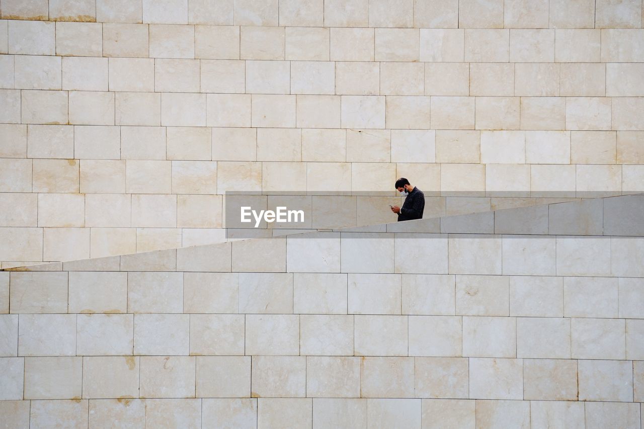 HIGH ANGLE VIEW OF WOMAN WALKING ON WALL