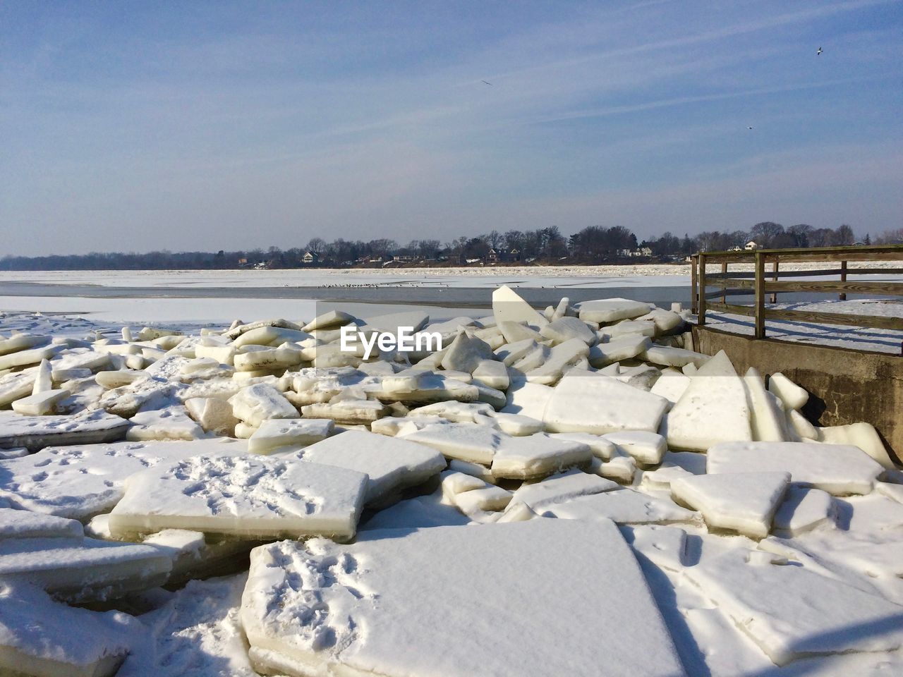 SNOW ON LAND BY SEA AGAINST SKY