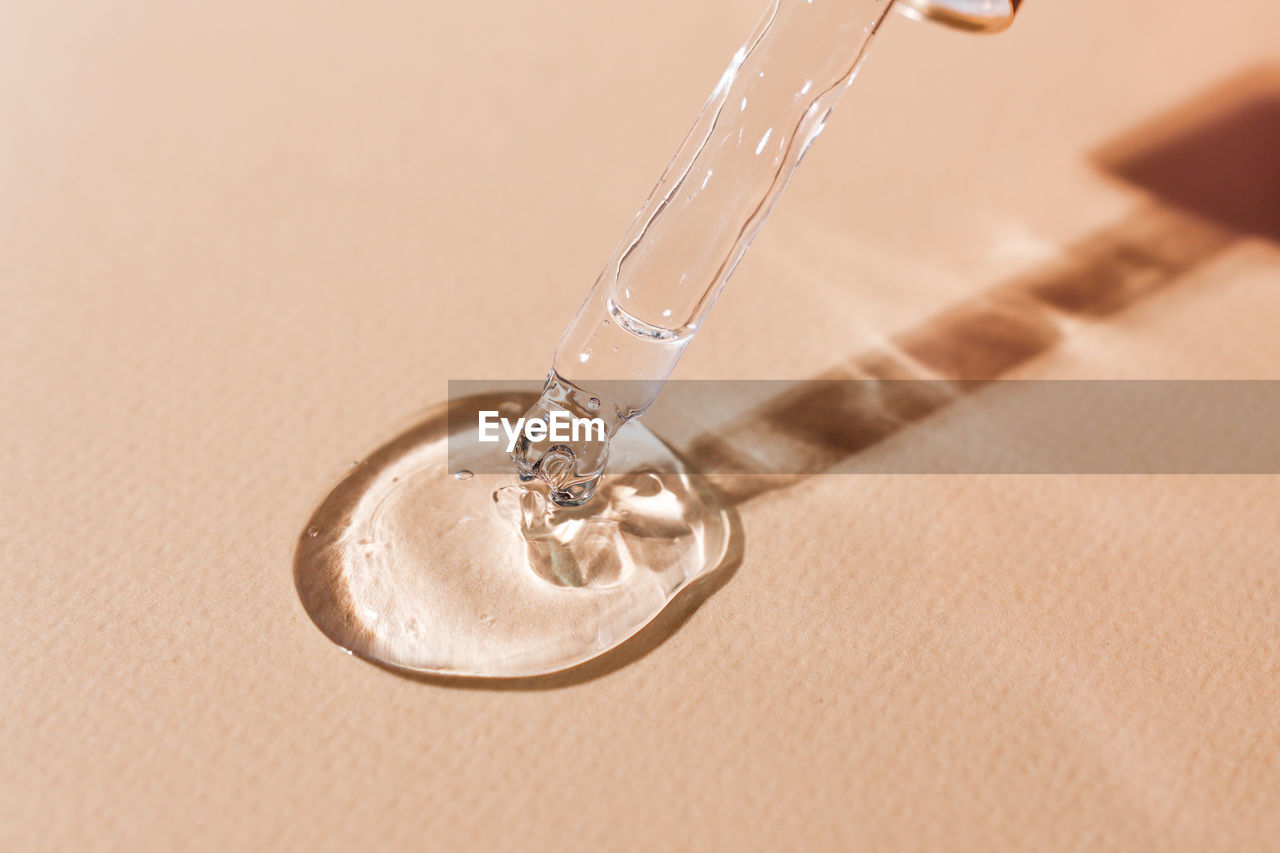Transparent cosmetic gel with bubbles on a beige background close-up. hyaluronic acid for skin